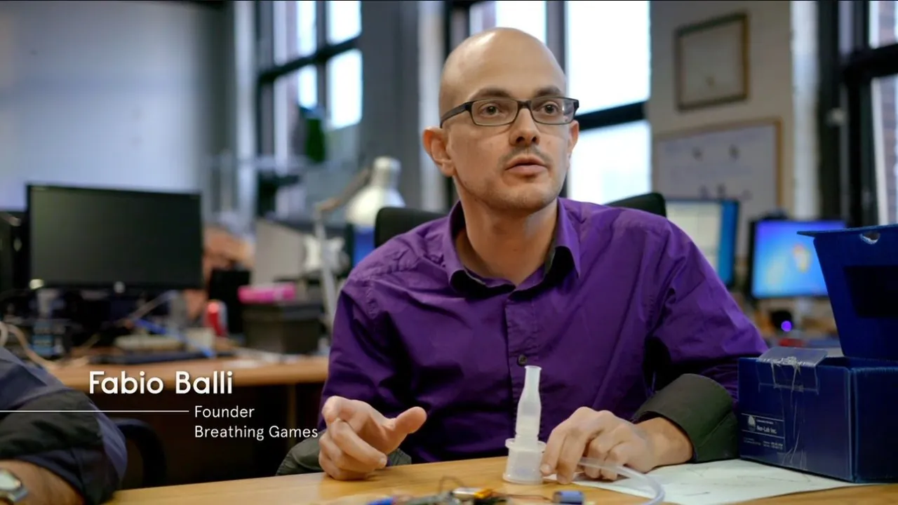 Fabio Balli, en chemise violette, présente un capteur de souffle de Breathing Games